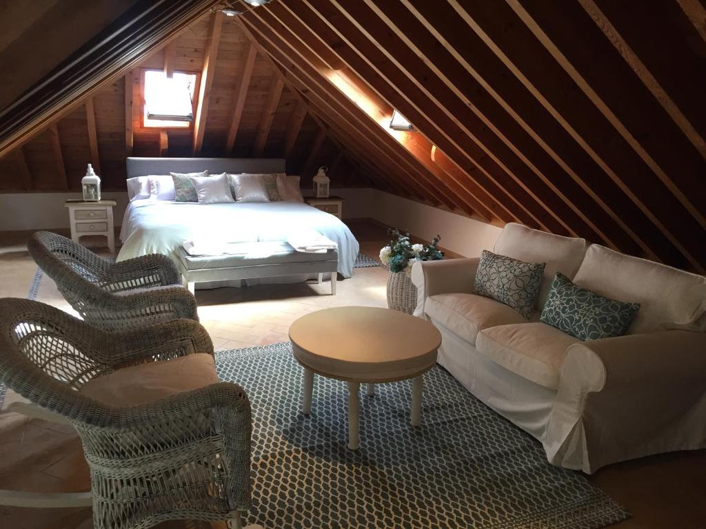 科尔多瓦Duplex Juderia的一间卧室配有一张床、一张沙发和椅子