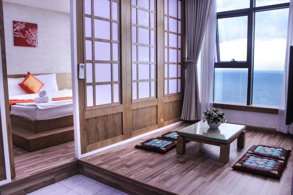 芽庄金海公寓的客房设有床、桌子和窗户。
