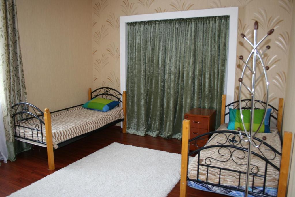 阿斯塔纳美洲旅舍的一间卧室设有两张床和窗户。