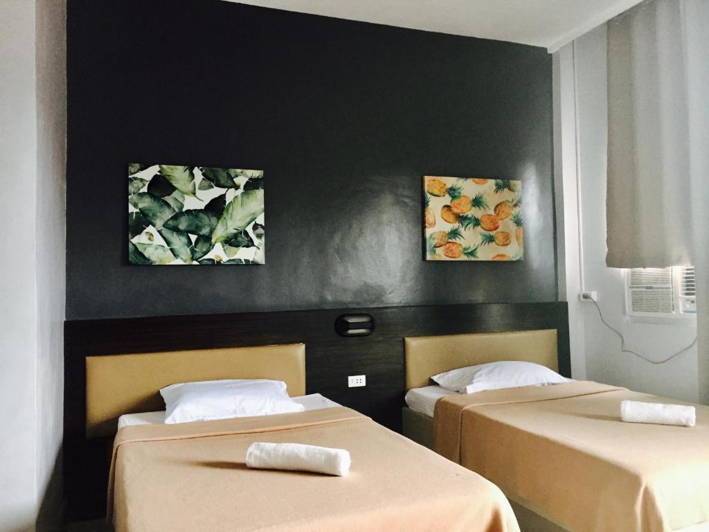 邦劳LEUX Hotel Alona Panglao的墙上画作的房间里设有两张床