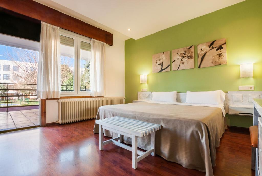 赫塔费洛斯奥利沃斯酒店的绿色卧室设有两张床和窗户