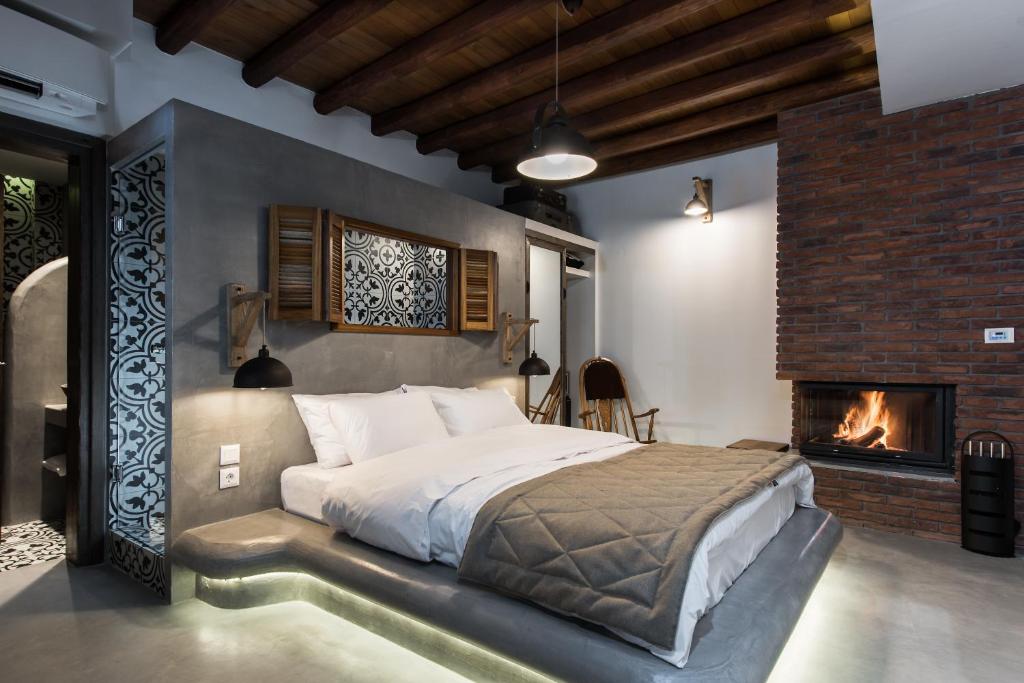 韦里亚Olganos VL Luxury Rooms & Suites的一间卧室设有一张大床和一个壁炉
