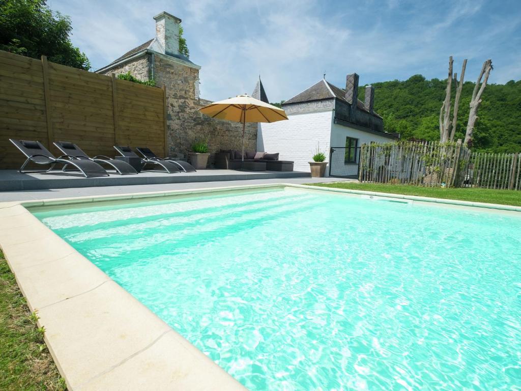 Hastière-par-delàModern Mansion in Hasti re par Del with Pool的一个带椅子和遮阳伞的游泳池