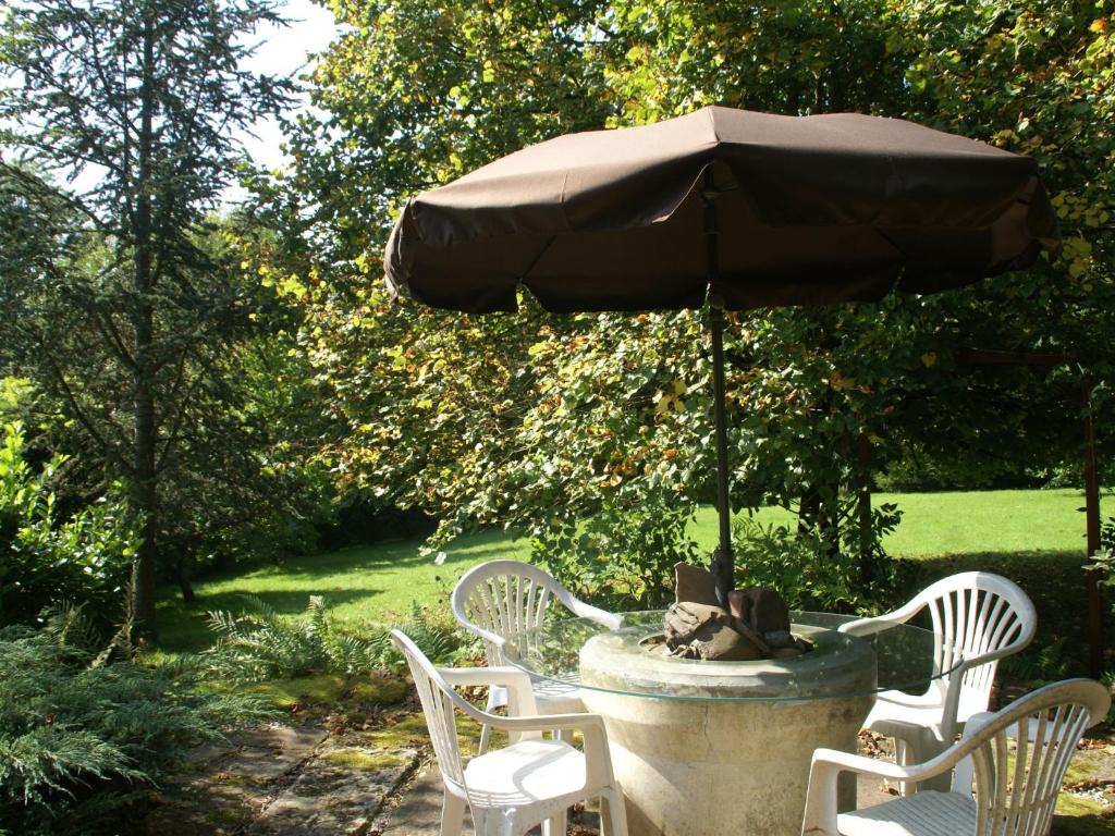 班莱班Holiday home near Chapelle Aux Bois的一个带椅子和遮阳伞的石头喷泉