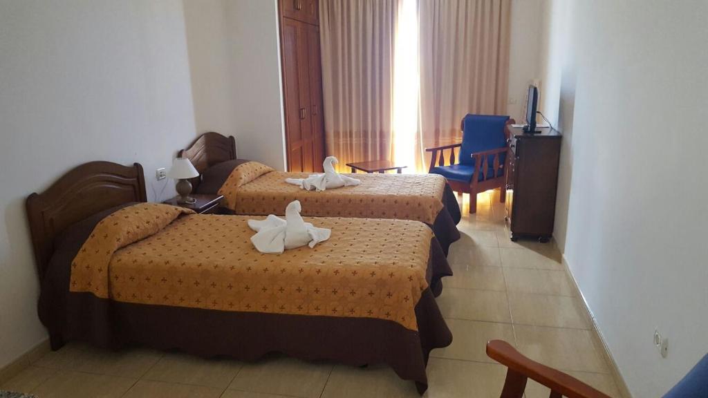 拉雷斯廷加Apartamentos Los Saltos的酒店客房,配有两张带毛巾的床