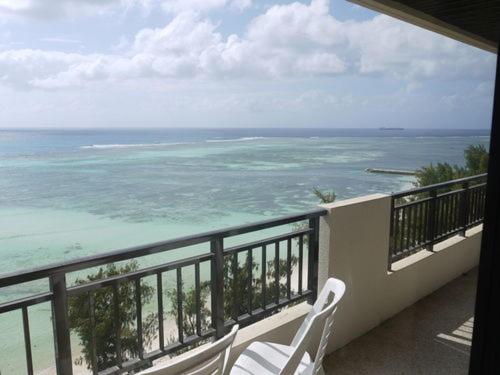 查兰卡诺亚宝瓶宫海滩酒店的阳台配有两把白色椅子,享有海景。