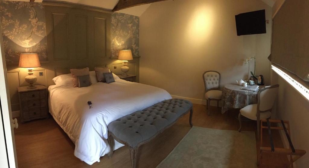Little MassinghamHill Farm Bed and Breakfast的一间卧室配有一张床、一张桌子和一台电视