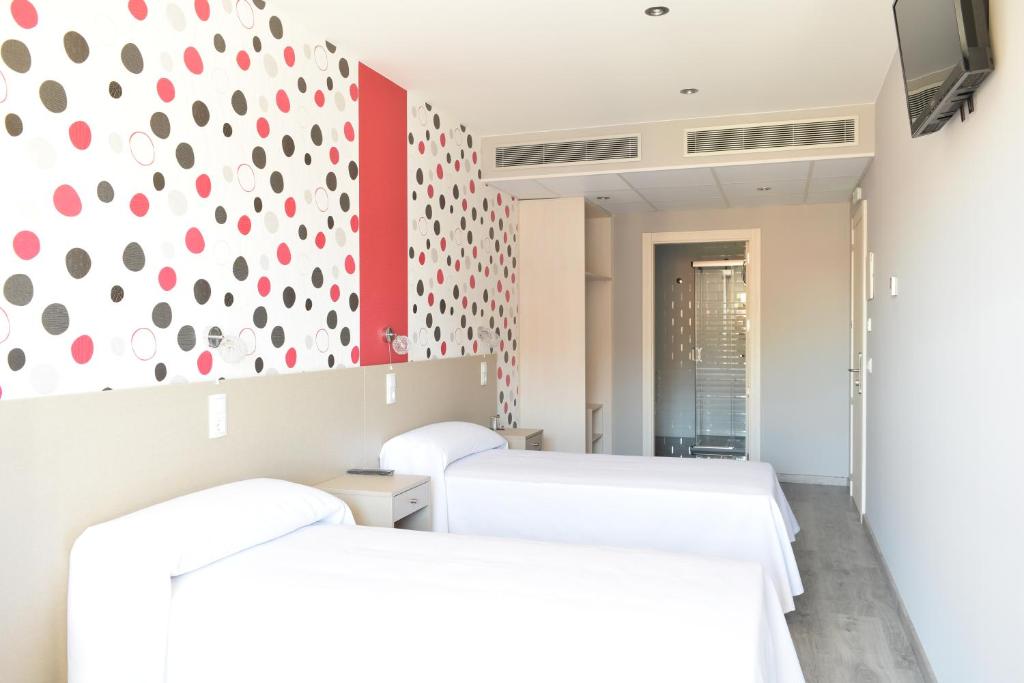 Torrente de CincaHotel Siskets的一间设有两张床和红色及白色墙壁的客房