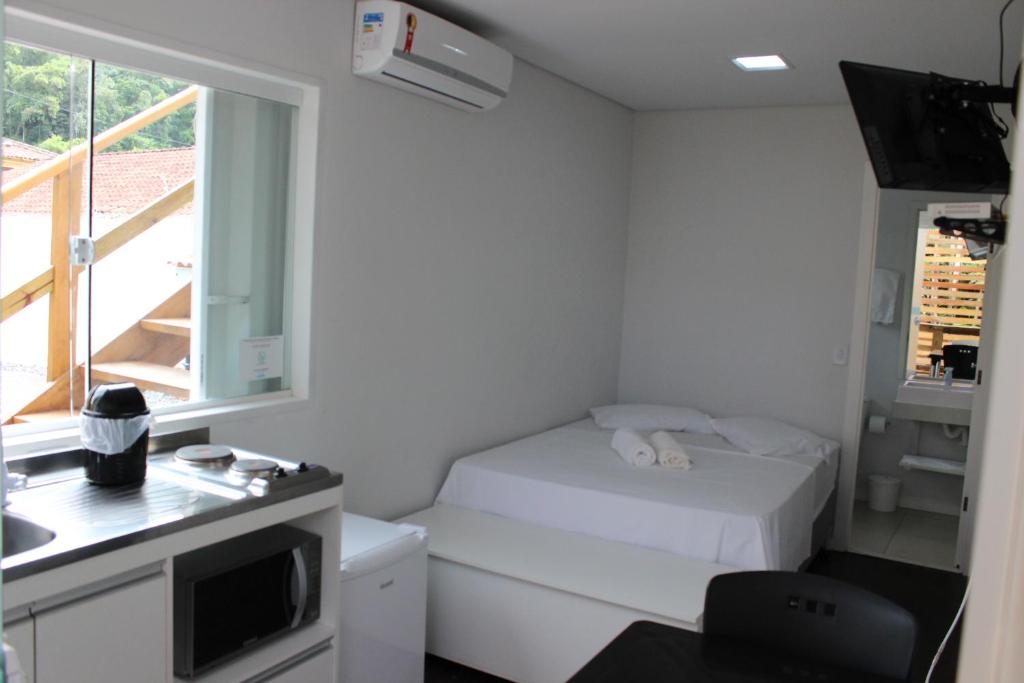 坎布里Praia Camburi - Studios Kuta的一间白色的小房间,配有床和窗户