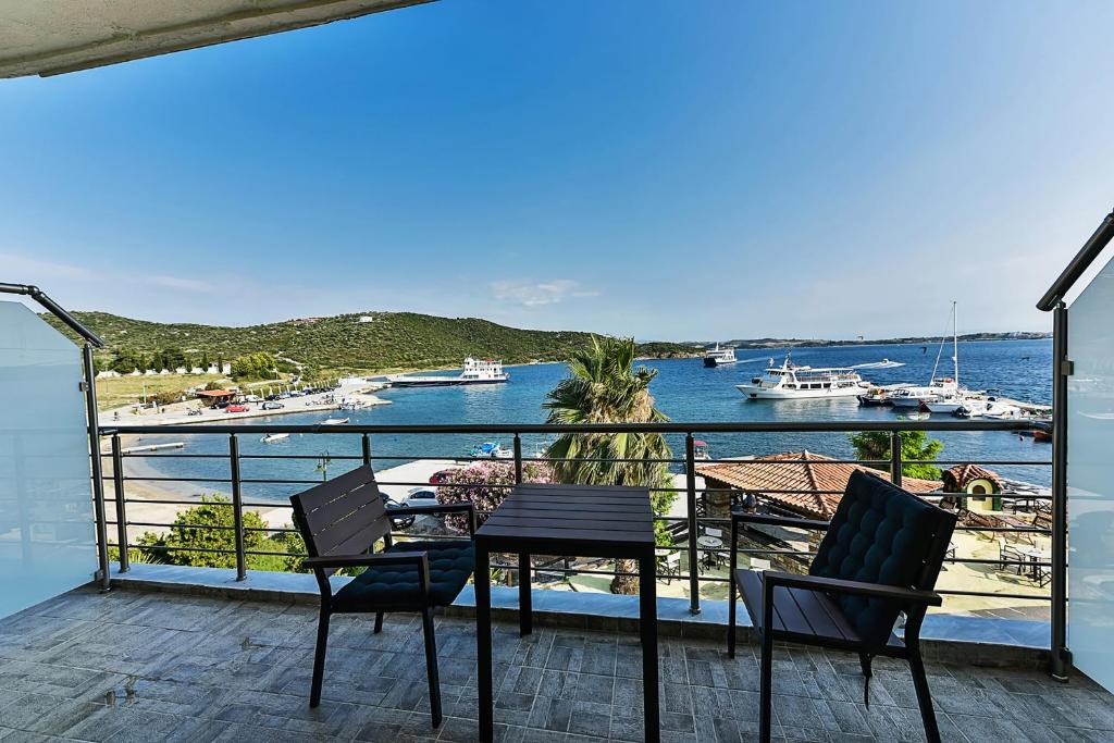 阿莫利亚尼岛Pension Limani的阳台配有桌椅,享有海港的景致。