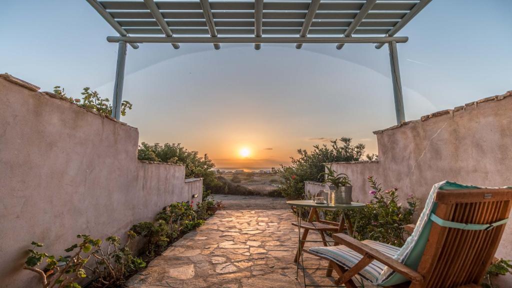 纳克索斯岛卡斯特拉基Alma Libre Villas的一个带桌椅的庭院,享有日落美景。
