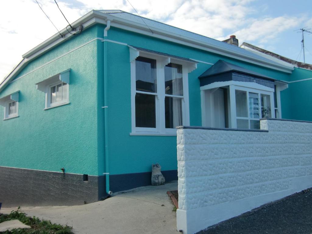 奥玛鲁奥马鲁绿色度假屋的蓝色的房子,前面有一只猫