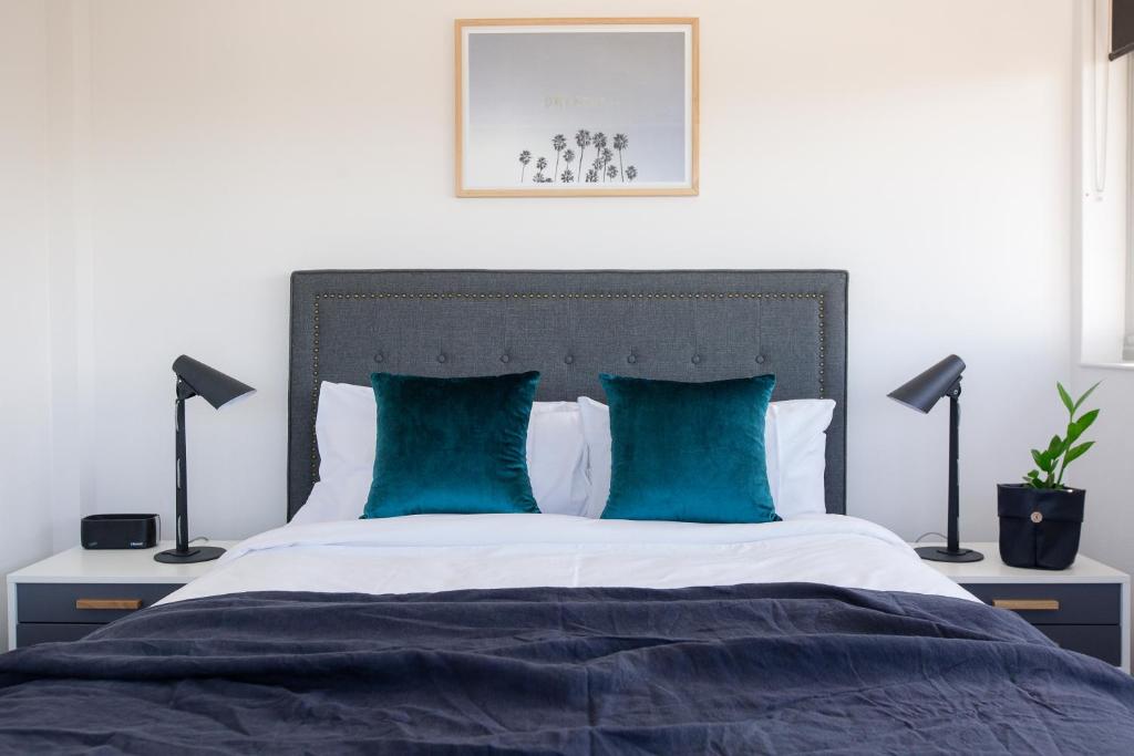 布里斯班山岭公寓酒店的一间卧室配有一张带蓝色枕头的大床