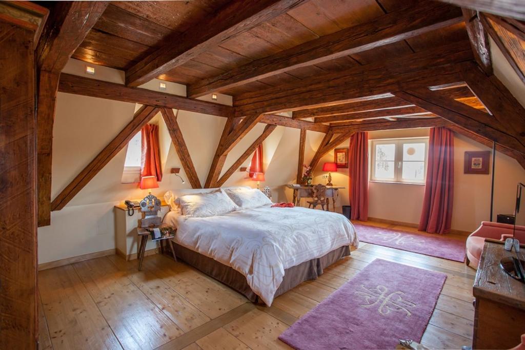斯特拉斯堡金盾酒店及水疗中心的一间卧室设有一张大床和木制天花板。