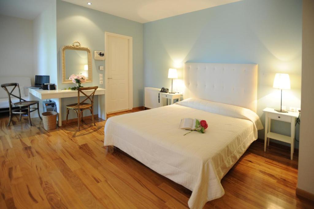 阿吉奥斯伊欧尼斯肯奇康精品酒店与简易别墅的卧室配有白色的床,床上有花