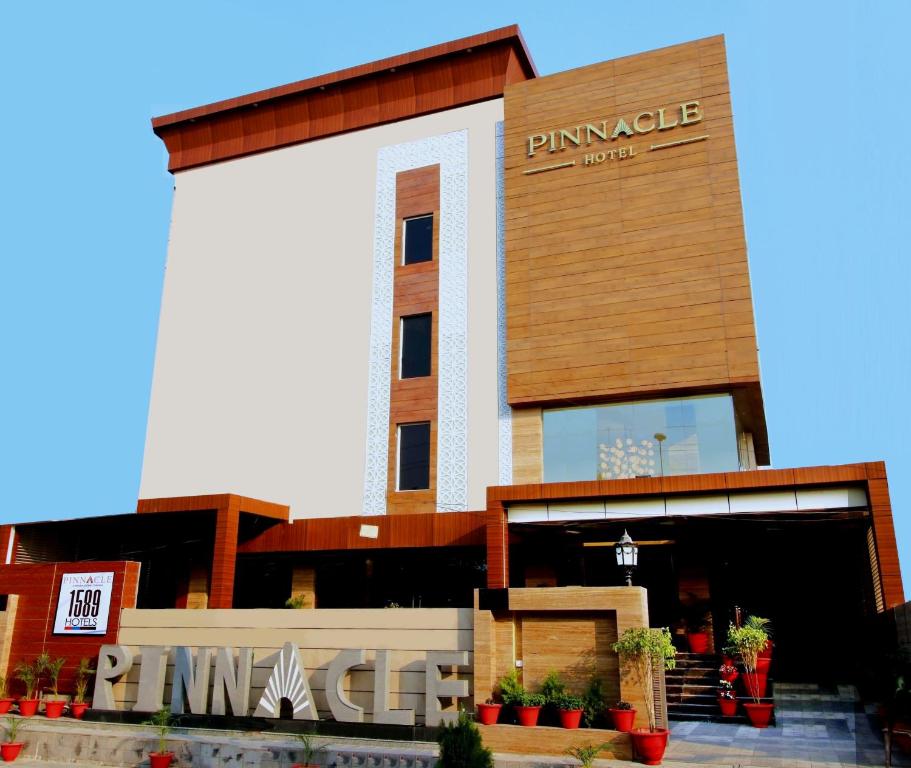 勒克瑙Pinnacle by Click Hotels, Lucknow的美洲狮建筑物入口的 ⁇ 染