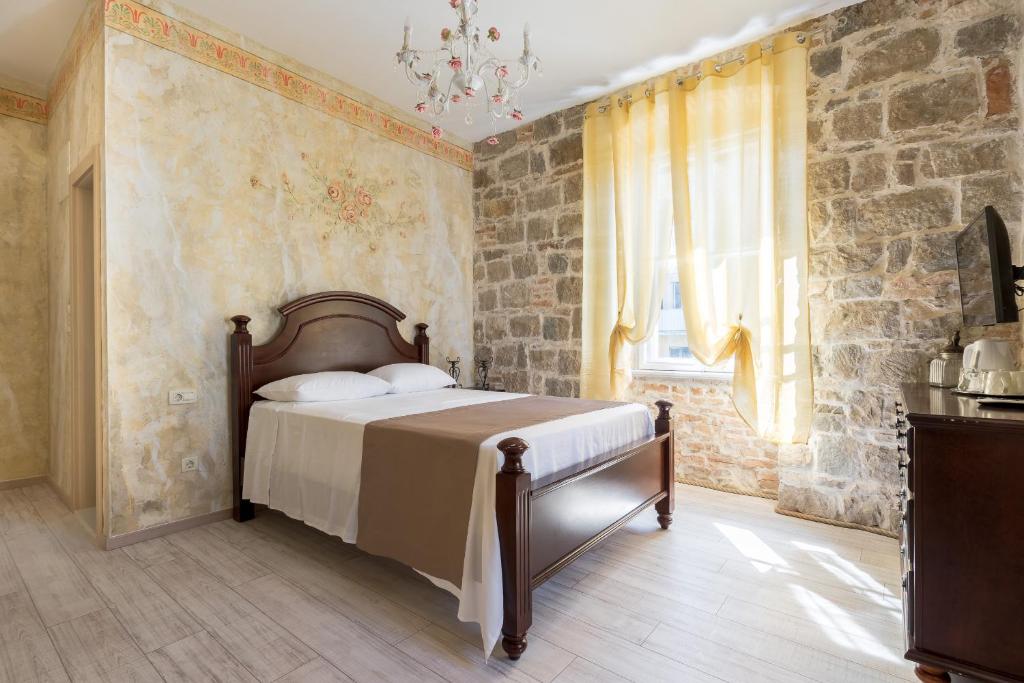 斯普利特彼得拉罗萨旅馆的一间卧室设有一张床和石墙