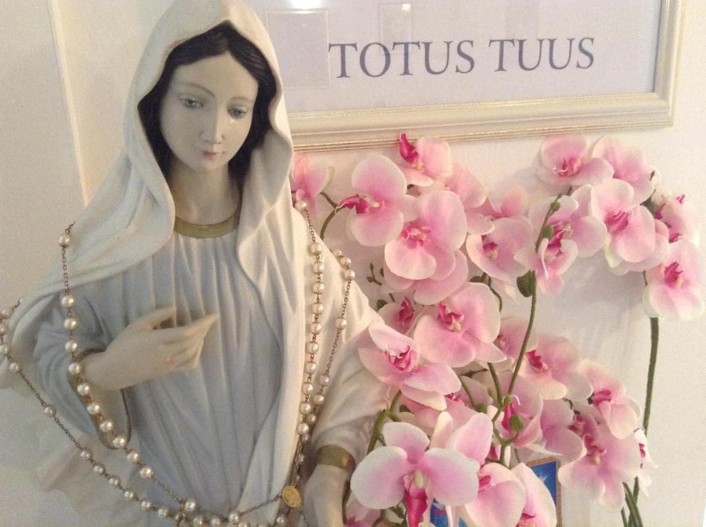 默主歌耶St Michael的粉红色花朵旁的女人的宗教雕像