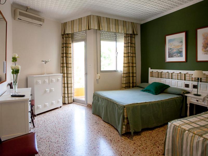 马萨龙Hotel Costa的一间卧室配有一张床、一张书桌和一个窗户。