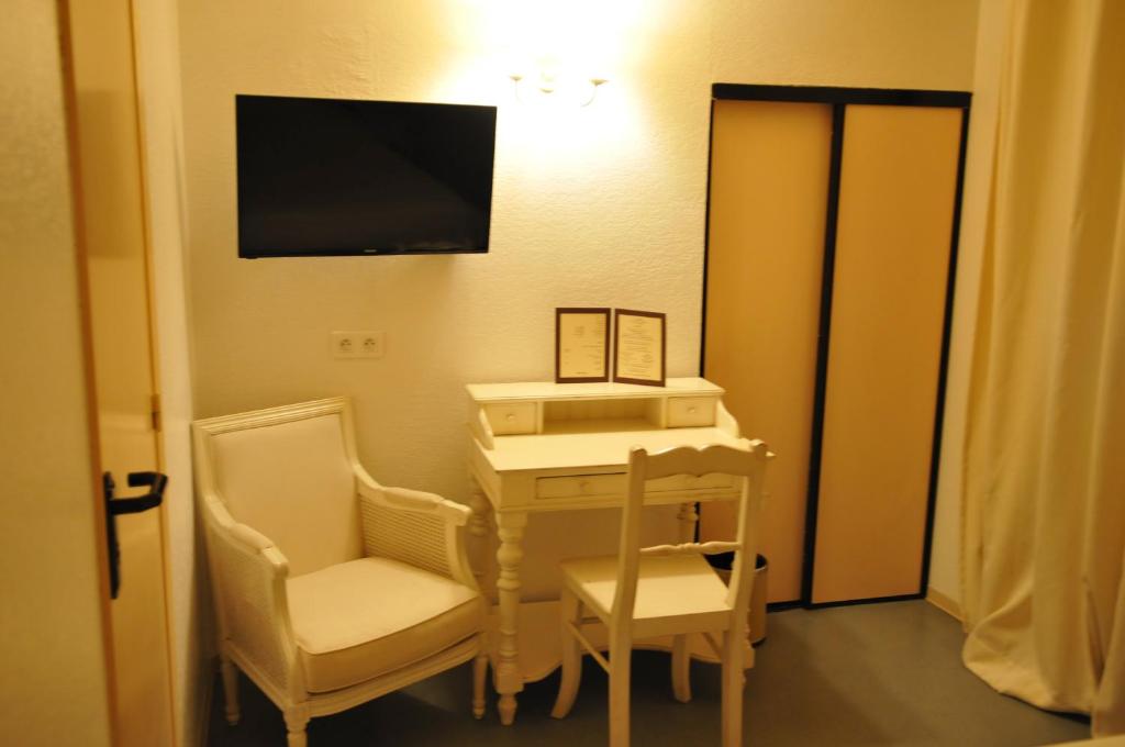 吉索纳恰弗朗西尼酒店的配有书桌、两把椅子和电视的房间