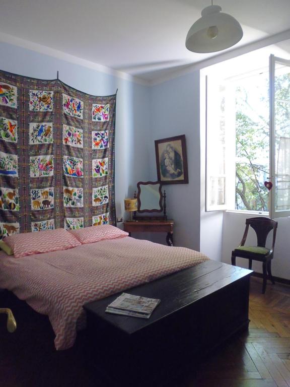科莫伊尔普拉塔诺公寓的一间卧室配有一张带毯子的床和窗户