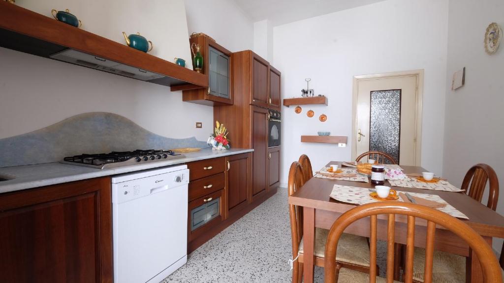 皮内托Orchidea 2 Pineto Vacanza的厨房配有桌子和白色炉灶烤箱。