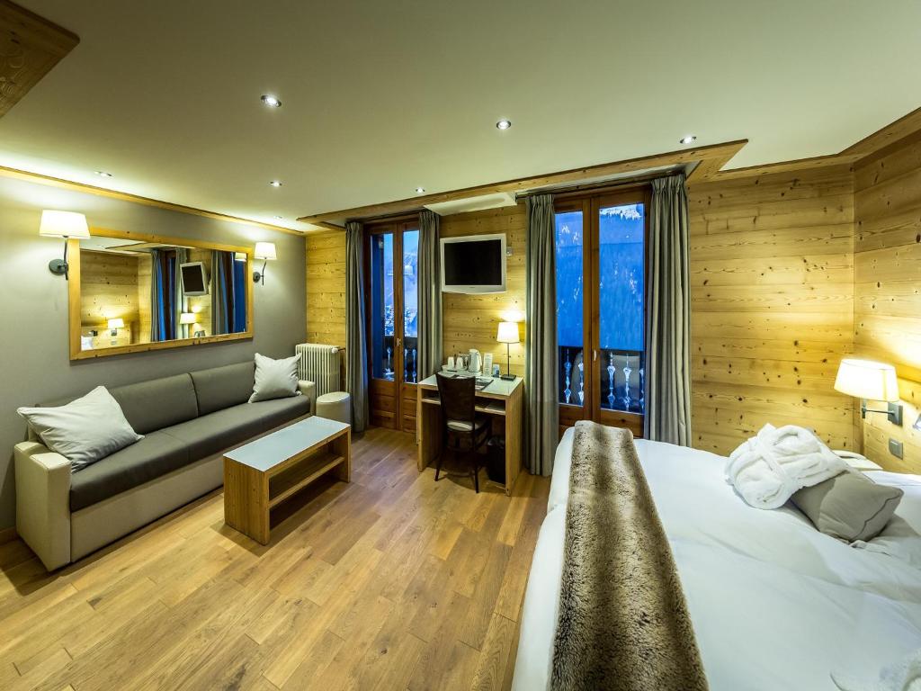 沙泰勒弗勒尔德内日酒店的一间卧室配有一张床、一张沙发和一张书桌