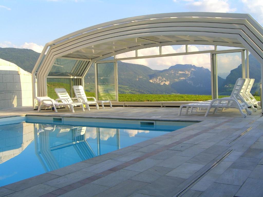 斯泰尼科Belvilla by OYO Villa Stenico的一个带椅子的游泳池和一个凉亭