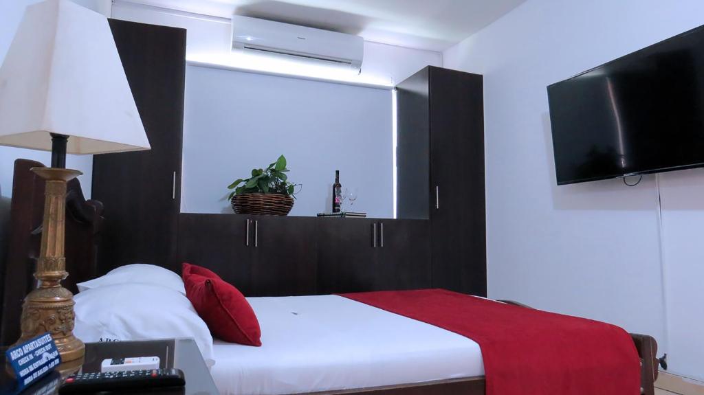 卡利阿科公寓的一间卧室配有一张床和一台平面电视
