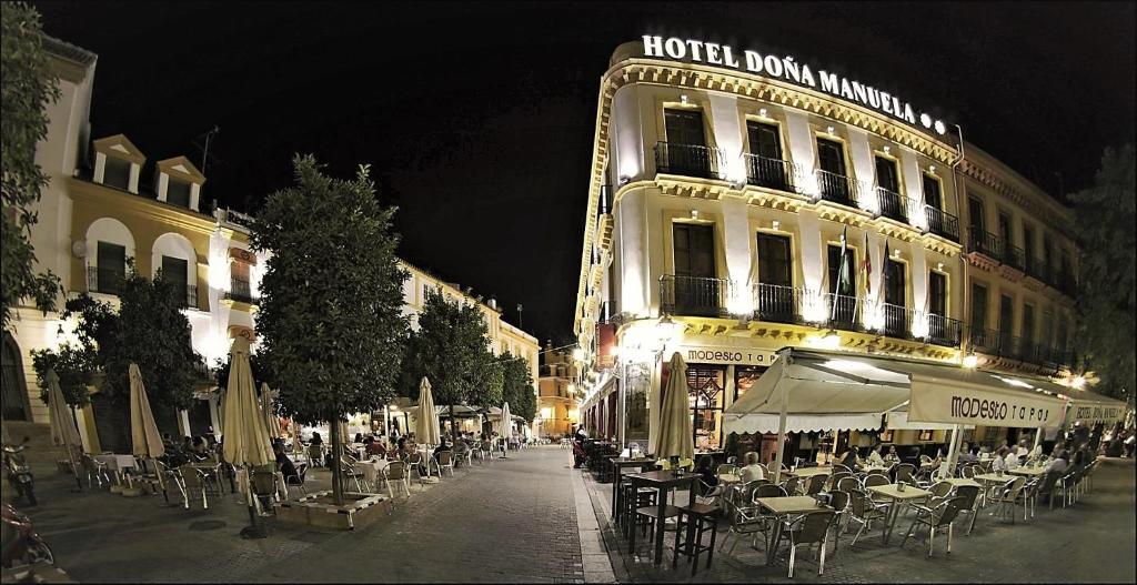 塞维利亚Basic Hotel Doña Manuela的大楼前一条带桌椅的街道