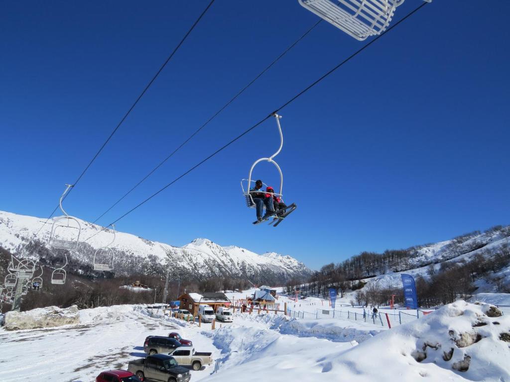 拉斯特朗卡斯Cabañas Aliwen的雪中滑雪缆车上的人