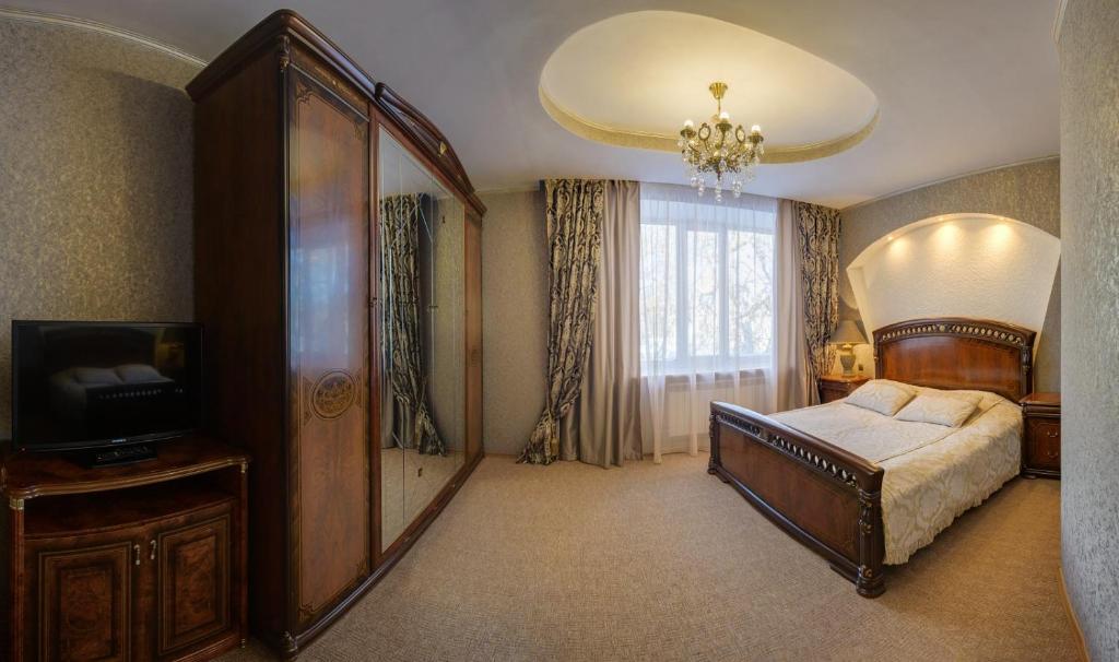 彼得罗巴甫洛夫斯克Ghostinitsa "Lina"的一间卧室配有一张床和一台电视