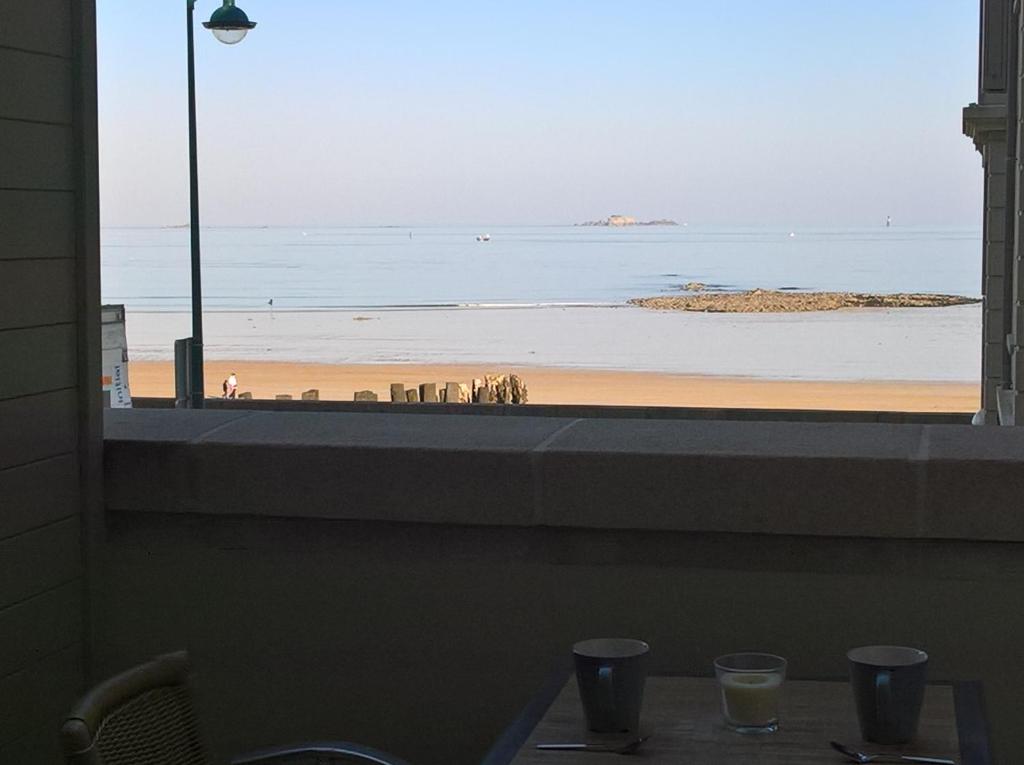 圣马洛Studio Le sillon malouin vue mer的从餐厅窗口可欣赏到海滩景色
