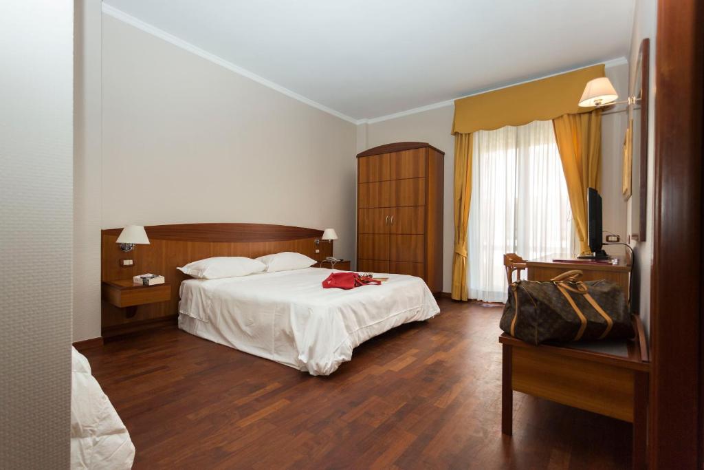诺奇卡瓦列雷酒店的卧室配有白色的床和木地板
