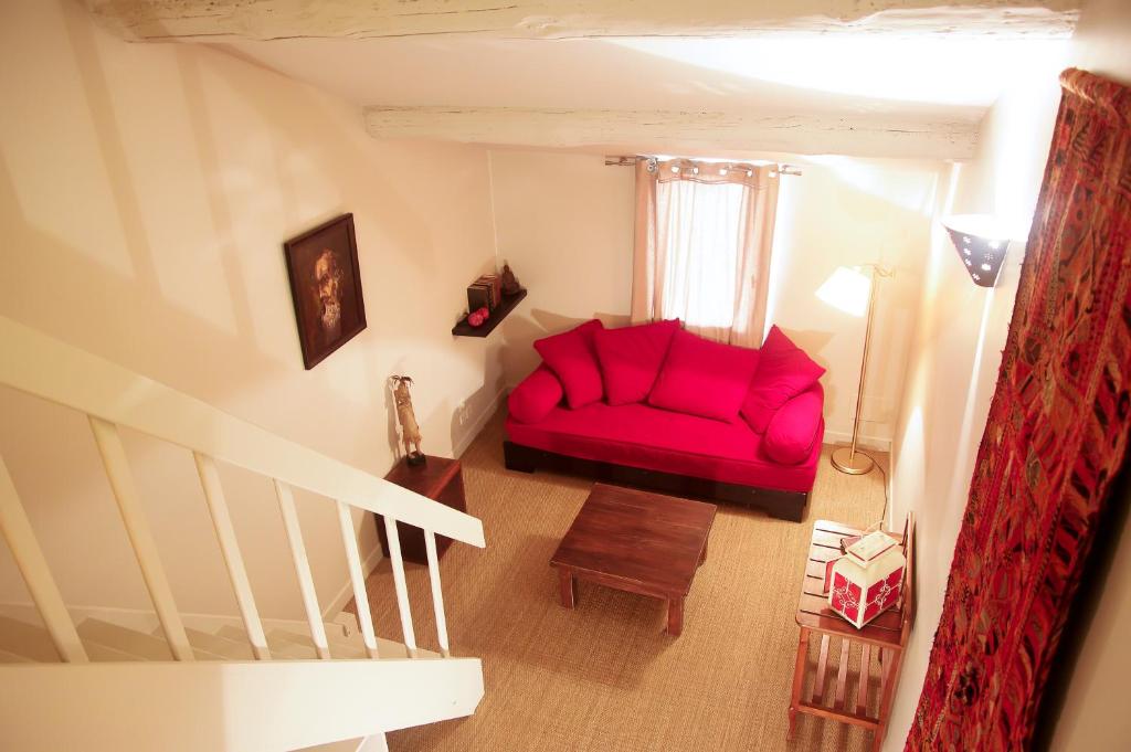 阿尔勒La Maison de Noémie的客厅里的一个红色沙发,带有窗户