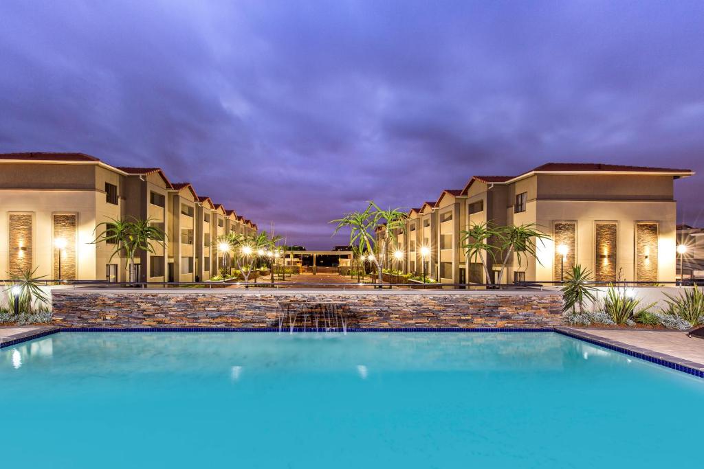 德班Savannah Park Luxury Apartments的晚上在酒店前面的一个游泳池