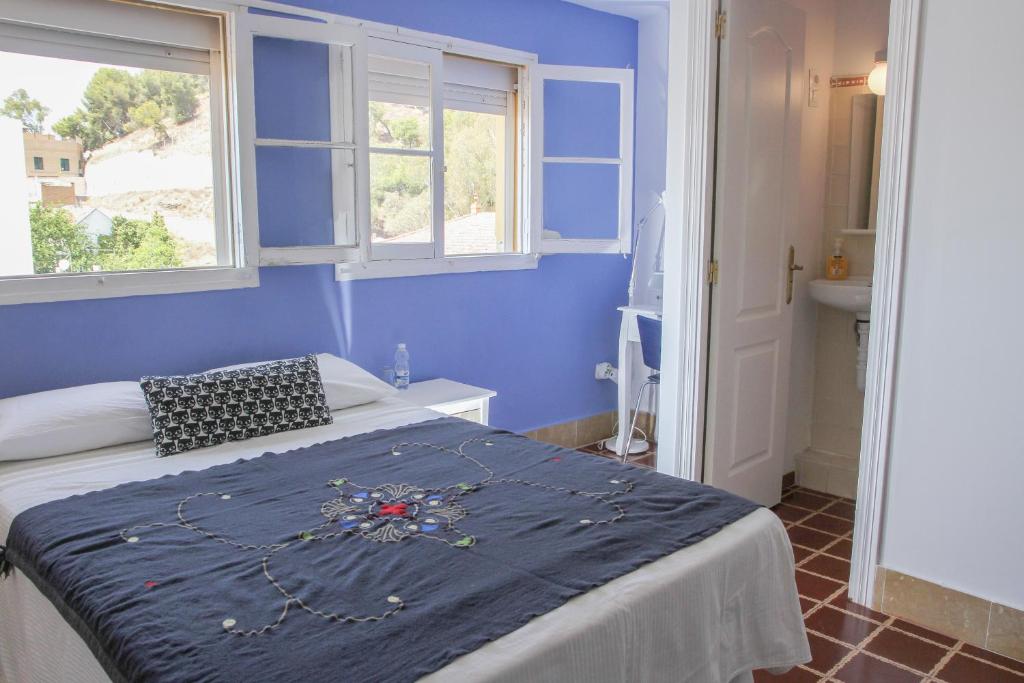 马拉加阿里西亚别墅旅馆的一间蓝色卧室,配有床和2个窗户