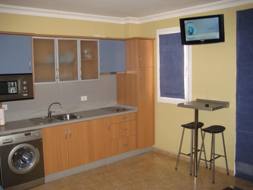 圣克鲁斯-德特内里费S/C de Tenerife, apartamento 1 dormitorio的一个带水槽的小厨房和墙上的电视
