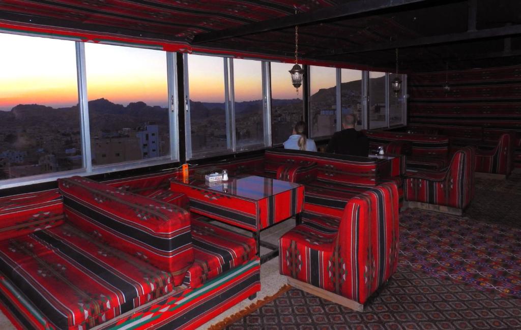 瓦迪穆萨佩特拉门大酒店 的一间设有红色椅子的餐厅,享有城市美景