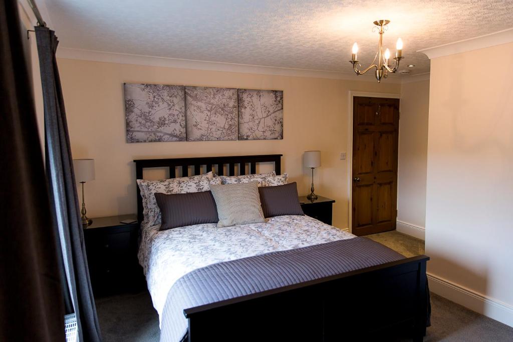霍特惠斯尔Belford House Self Check-in Rooms的一间卧室配有一张大床和一个吊灯。