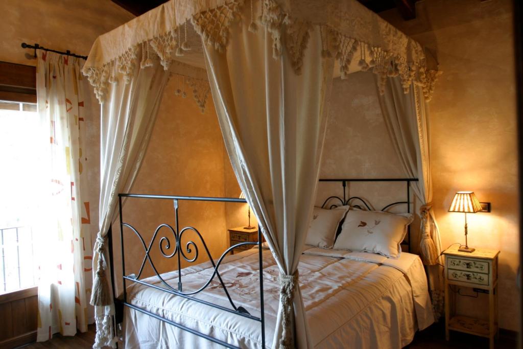 Caspueñas克普利由郊区艾尔玛兰艾尔酒店的一间卧室设有天蓬床和窗户。