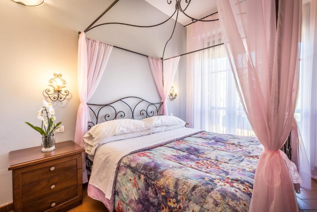 佛罗伦萨安帝卡莫尼耶B&B酒店的一间卧室配有一张带粉红色窗帘的天蓬床