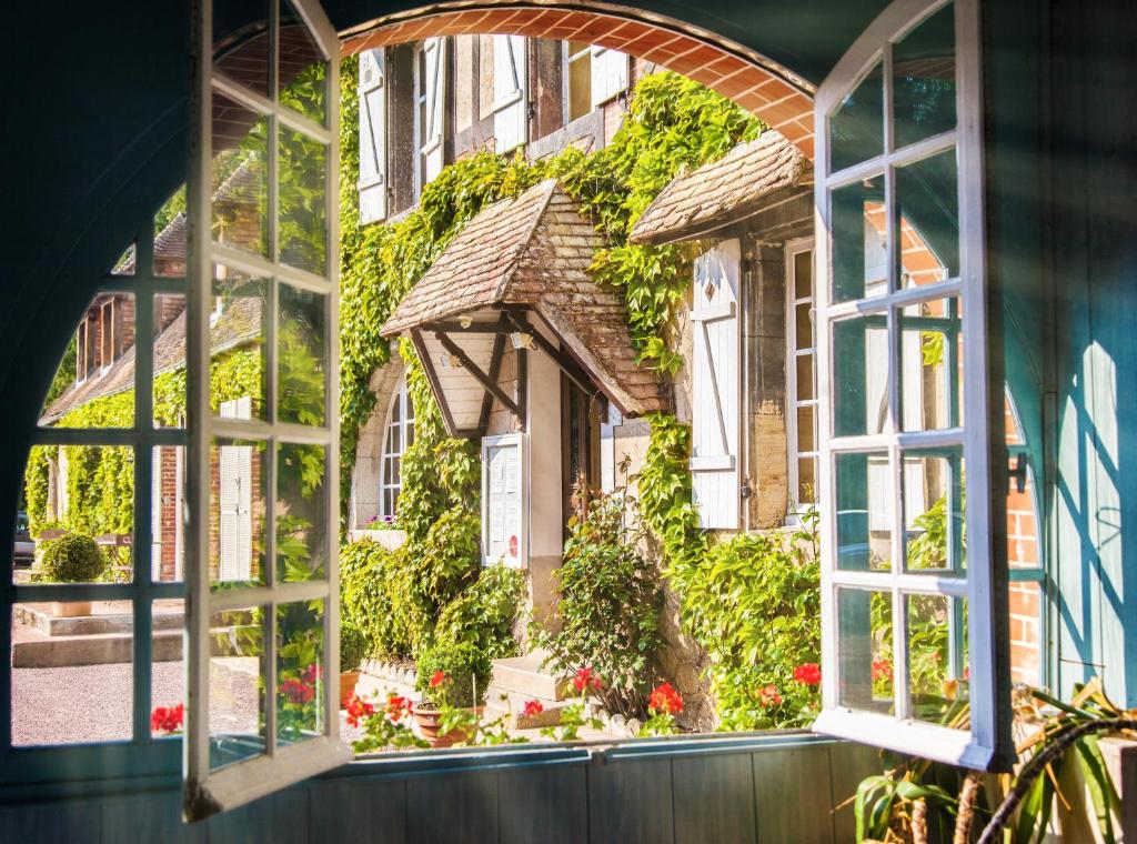 Macé乐伊尔德斯酒店的开敞的窗户,眺望着鲜花的房子