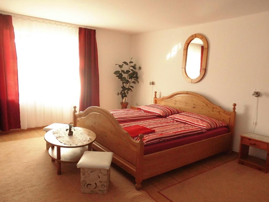 沙罗什保陶克Fenyves Apartman的一间卧室配有一张床、一张桌子和一面镜子