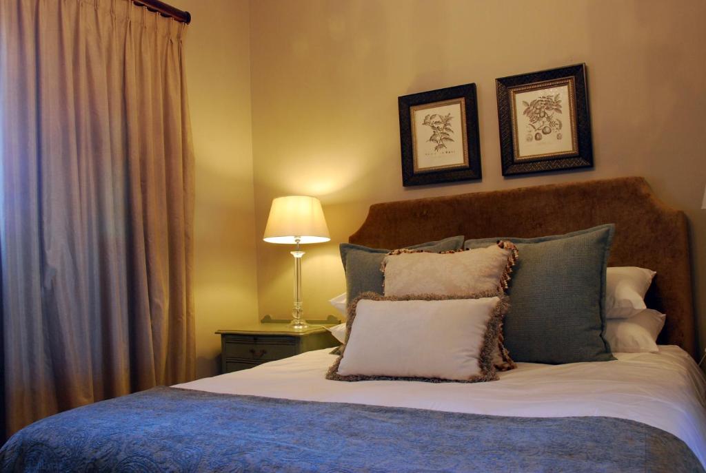 丹地Sneezewood Farm Bed&Breakfast and Self-Catering Cottage的一间卧室配有带枕头和台灯的床