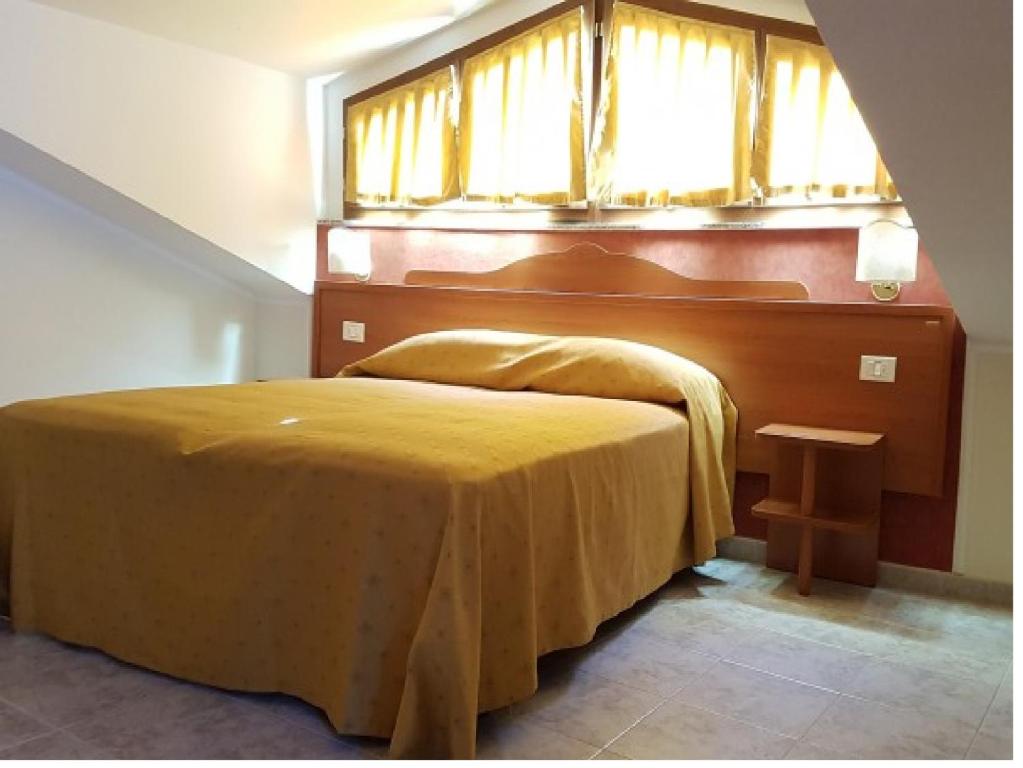 圣乔瓦尼·罗通多Hotel Dei Cappuccini的一间卧室设有一张黄色的床和窗户