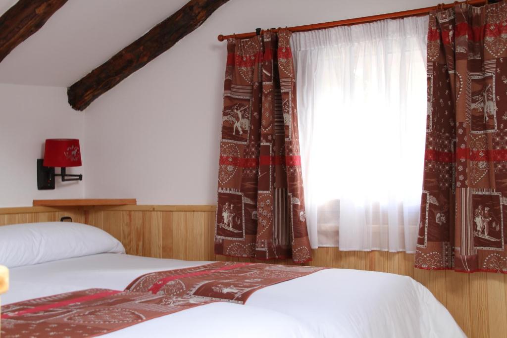 索尔德乌布鲁塞尔酒店的一间卧室设有两张床,窗户配有窗帘