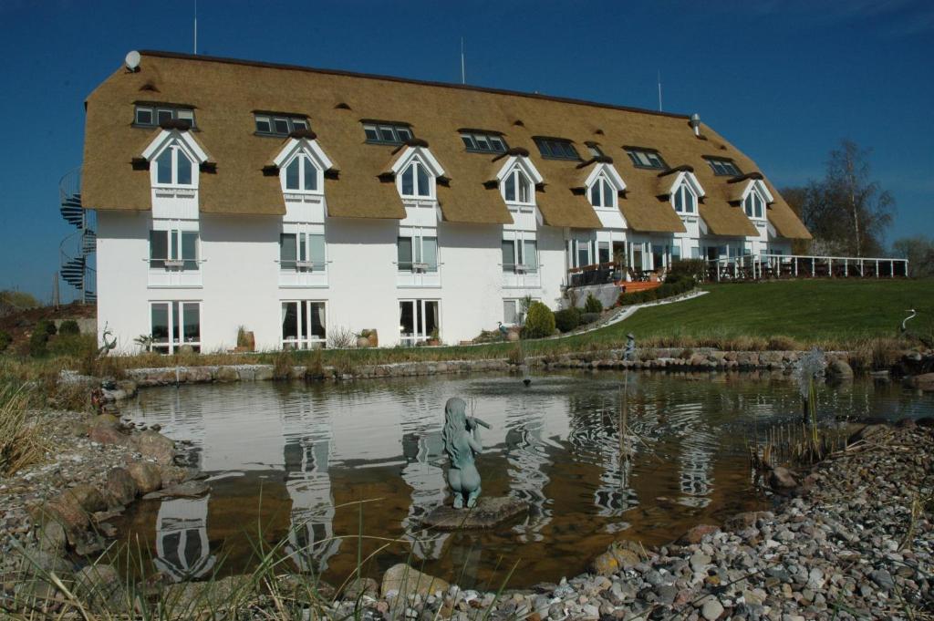 剑桥郡阿拉格海景酒店的一座建筑,前面的池塘里有一个雕像