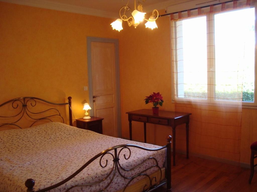 Siros查纳住宿加早餐旅馆的一间卧室设有床、两张桌子和一扇窗户