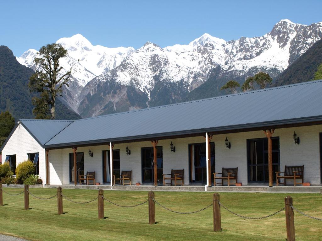 福克斯冰川库克山景汽车旅馆的一座白楼,底楼是白雪覆盖的群山